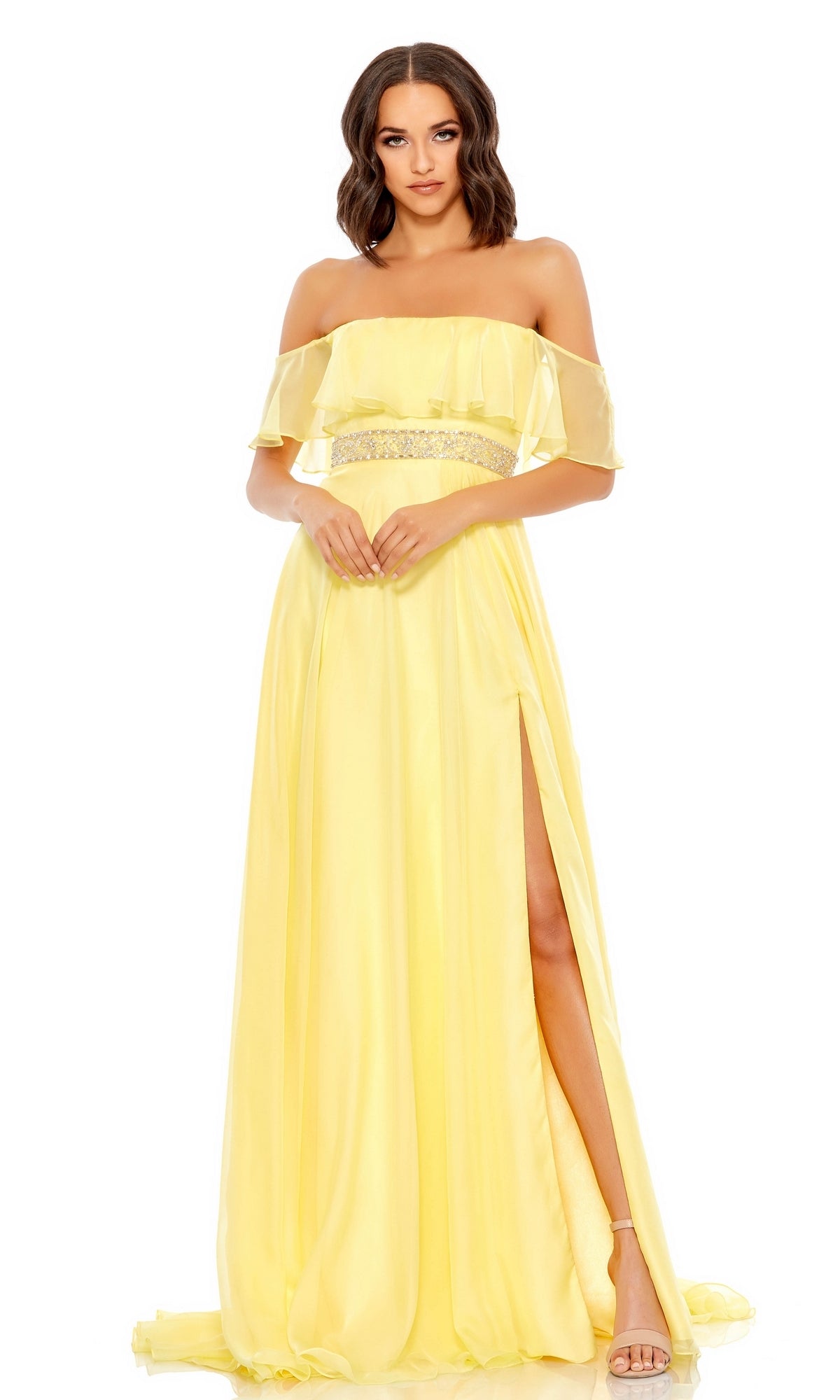 A woman faces forward in the Beaded-Waist Off-Shoulder Long Prom Dress 67817—a floor-length yellow gown with a thigh-high slit and decorative waistband.